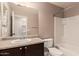 The neutral-toned bathroom features a single sink vanity with a large mirror and a shower-tub combo at 7769 W Bonitos Dr, Phoenix, AZ 85035