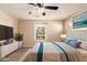 This bedroom features a ceiling fan, large bed, wood-look floors and a window for lots of natural light at 7769 W Bonitos Dr, Phoenix, AZ 85035