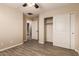 This bedroom features wood look floors, a ceiling fan and an adjacent closet and bathroom at 7769 W Bonitos Dr, Phoenix, AZ 85035