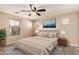 This bedroom features a ceiling fan, large bed, wood-look floors and multiple windows for lots of natural light at 7769 W Bonitos Dr, Phoenix, AZ 85035