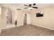 This bedroom features wood look floors, a ceiling fan and an adjacent bathroom at 7769 W Bonitos Dr, Phoenix, AZ 85035