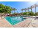 A refreshing community pool is lined with tall palms and green trees, with a splash pad nearby at 7769 W Bonitos Dr, Phoenix, AZ 85035