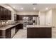 Modern kitchen with stainless steel appliances, island, and dark wood cabinetry at 7769 W Bonitos Dr, Phoenix, AZ 85035