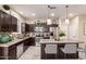 Modern kitchen features stainless steel appliances, dark wood cabinets, and a large island with seating at 7769 W Bonitos Dr, Phoenix, AZ 85035