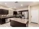 Well-lit kitchen featuring an island, stainless steel appliances, and dark cabinetry at 7769 W Bonitos Dr, Phoenix, AZ 85035