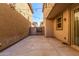 Back patio with concrete pavers and a gate leading to neighboring yards, strung with patio lights at 7769 W Bonitos Dr, Phoenix, AZ 85035