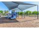 Shaded playground featuring slides, swings, and climbing structures on a wood chip surface at 7769 W Bonitos Dr, Phoenix, AZ 85035