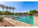 Community pool featuring beach entry, palm trees, cabanas, and clear blue water on a sunny day at 7769 W Bonitos Dr, Phoenix, AZ 85035