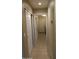 Hallway with tile flooring, storage closets, and access to the laundry area at 8014 W Beaubien Dr, Peoria, AZ 85382