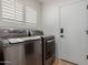 This laundry room features stainless steel washer and dryer, shuttered window, and a convenient door to the side at 9208 N 83Rd St, Scottsdale, AZ 85258