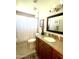 Bathroom featuring wood vanity, framed mirror, and shower with patterned curtain at 9807 W Mcrae Way, Peoria, AZ 85382