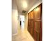 Bright hallway featuring tile flooring and built in wood storage cabinets at 9807 W Mcrae Way, Peoria, AZ 85382