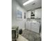 Bright laundry room featuring white washer/dryer, cabinets, shuttered window and decor at 9807 W Mcrae Way, Peoria, AZ 85382