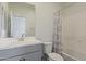 Clean bathroom featuring a toilet, shower-tub combo with a patterned curtain, and gray vanity at 10034 E Thunderbolt Ave, Mesa, AZ 85212