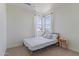 Simple bedroom featuring a twin bed, neutral walls, carpet, and bright natural light at 10034 E Thunderbolt Ave, Mesa, AZ 85212