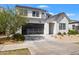 Contemporary home showcases a gray garage door and xeriscaped front yard, blending style and sustainability at 10034 E Thunderbolt Ave, Mesa, AZ 85212