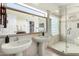Luxurious bathroom featuring dual sinks, a glass-enclosed shower, and neutral tiling at 1018 E Knoll St, Mesa, AZ 85203