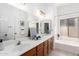 Well-lit bathroom with double sinks, a large mirror, and a bathtub-shower combo at 1018 E Knoll St, Mesa, AZ 85203