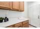 Functional laundry room with oak cabinets, white countertop, and easy access at 1018 E Knoll St, Mesa, AZ 85203