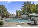 Community pool surrounded by lounge chairs and mature trees, perfect for relaxation at 1095 W Sandy Banks --, Gilbert, AZ 85233