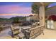 Backyard patio with comfortable seating, a grill, and lush landscaping at 11462 E Kora Way, Scottsdale, AZ 85255