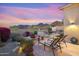 Landscaped backyard with stone patio, lounge chairs, flowers, and mountain views at 11462 E Kora Way, Scottsdale, AZ 85255