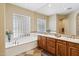 Bright bathroom featuring a double vanity, beautiful tile accents, and a luxurious soaking tub at 11462 E Kora Way, Scottsdale, AZ 85255