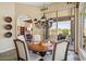 Elegant dining room with a chandelier, an arched doorway, and access to the patio at 11462 E Kora Way, Scottsdale, AZ 85255
