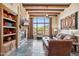 Comfortable living room featuring a stone fireplace, wood beams, and backyard views at 11462 E Kora Way, Scottsdale, AZ 85255