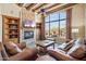 Cozy living room with a stone fireplace, built-in shelves, and views of the backyard patio at 11462 E Kora Way, Scottsdale, AZ 85255