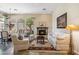 Cozy living room featuring a stone fireplace and large windows with backyard views at 11462 E Kora Way, Scottsdale, AZ 85255