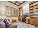 Inviting home office space features coffered ceilings, custom shelves, and large shuttered windows at 11462 E Kora Way, Scottsdale, AZ 85255