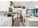 Modern kitchen with stainless steel appliances, tile backsplash, and large kitchen island looking into living room at 1151 S Avoca --, Mesa, AZ 85208
