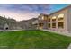 Expansive backyard featuring a lush lawn, mountain views, fireplace, and an inviting outdoor area with scenic sunset views at 14049 S 8Th St, Phoenix, AZ 85048