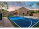 Backyard view showcasing a well-maintained basketball court next to a luxury house with mountain views and outdoor fireplace at 14049 S 8Th St, Phoenix, AZ 85048
