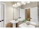 Well-lit bathroom with a pedestal sink, large mirror, and modern fixtures at 14049 S 8Th St, Phoenix, AZ 85048