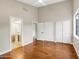 Spacious bedroom featuring a ceiling fan, hardwood floors, and sliding closet doors at 14049 S 8Th St, Phoenix, AZ 85048