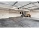 Spacious three-car garage with concrete floors and storage shelving at 14049 S 8Th St, Phoenix, AZ 85048