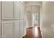 Hallway with hardwood floors and built in storage leading to an archway at 14049 S 8Th St, Phoenix, AZ 85048