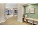 Hallway with wooden bench seating and two abstract pieces of art on a green accent wall at 14049 S 8Th St, Phoenix, AZ 85048