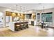 Modern kitchen with large island, bar stool seating, pendant lights, and stainless steel appliances next to dining area at 14049 S 8Th St, Phoenix, AZ 85048