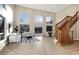 Spacious living room boasting soaring ceilings, large windows, hardwood floors, and a curved staircase at 14049 S 8Th St, Phoenix, AZ 85048