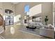 Bright living room featuring a high ceiling, modern chandelier, and large windows at 14049 S 8Th St, Phoenix, AZ 85048