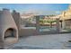 Outdoor fireplace on concrete patio, enclosed by a fence and a view of the pool at 14049 S 8Th St, Phoenix, AZ 85048