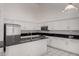 Spacious kitchen featuring white cabinets, black countertops, stainless steel appliances, and modern lighting at 14470 N 98Th Pl, Scottsdale, AZ 85260
