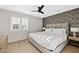 Bright bedroom featuring a comfortable bed, ceiling fan, and stylish geometric accent wall at 16409 N 65Th Pl, Scottsdale, AZ 85254
