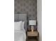 Close up of bedroom nightstand with lamp, decorative accent wall, and king bed at 16409 N 65Th Pl, Scottsdale, AZ 85254