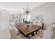 Open-concept dining area with a large wood table, upholstered chairs, and modern light fixture at 16409 N 65Th Pl, Scottsdale, AZ 85254