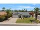 Charming single-story home with a well-manicured lawn, lush landscaping, and attached two-car garage at 16409 N 65Th Pl, Scottsdale, AZ 85254