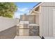 Modern outdoor kitchen featuring a stainless steel grill and beautiful tiled backsplash at 16409 N 65Th Pl, Scottsdale, AZ 85254